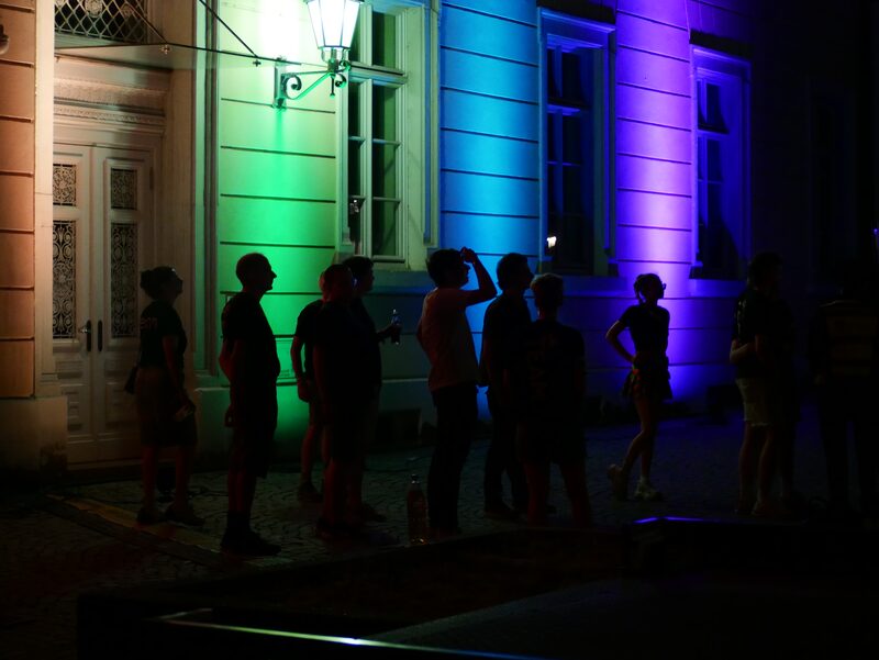 In Regenbogenfarben angestrahltes Gebäude am Karolinenplatz bei Nacht