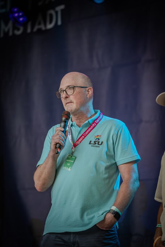 Person am Mikrofon auf der Bühne während der zweiten Podiumsrunde